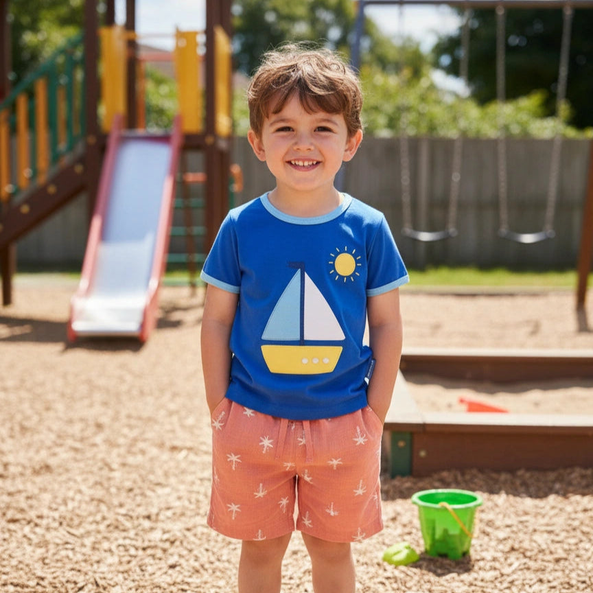 Boy wearing Toby tiger applique sailboat tshirt  in a park