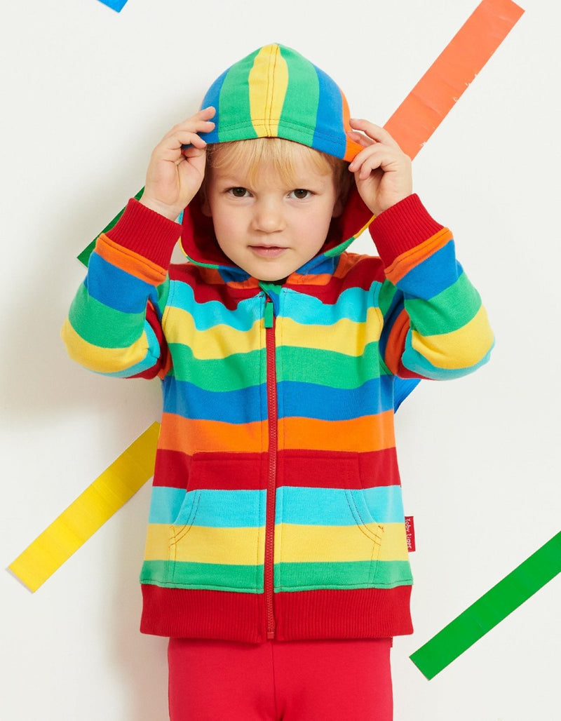 Child wearing a colorful striped hoodie and pants on a white background