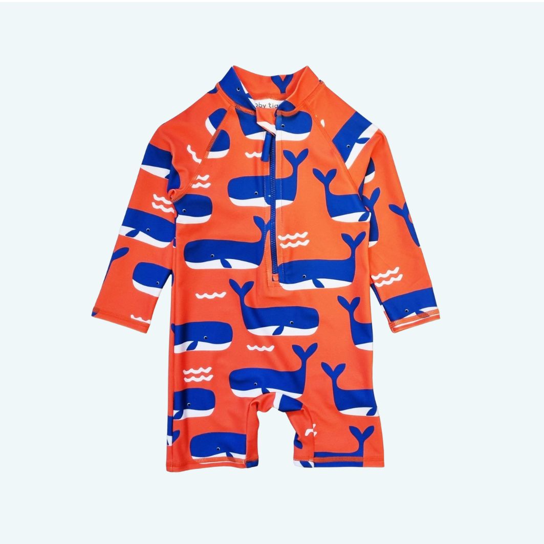 Orange and blue children's swimsuit with whale pattern on a white background