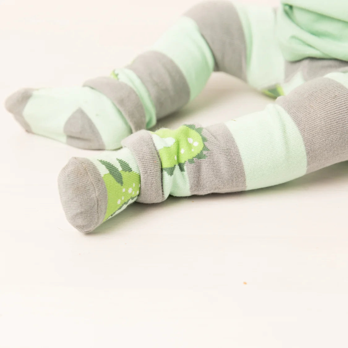 Pair of green and gray striped socks on a light background