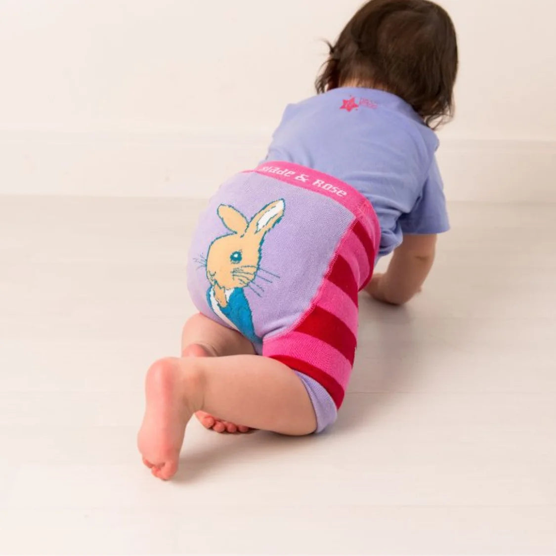 Child wearing a diaper with a cartoon character on a plain background