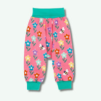 Pink children's pants with floral and bee pattern on a white background