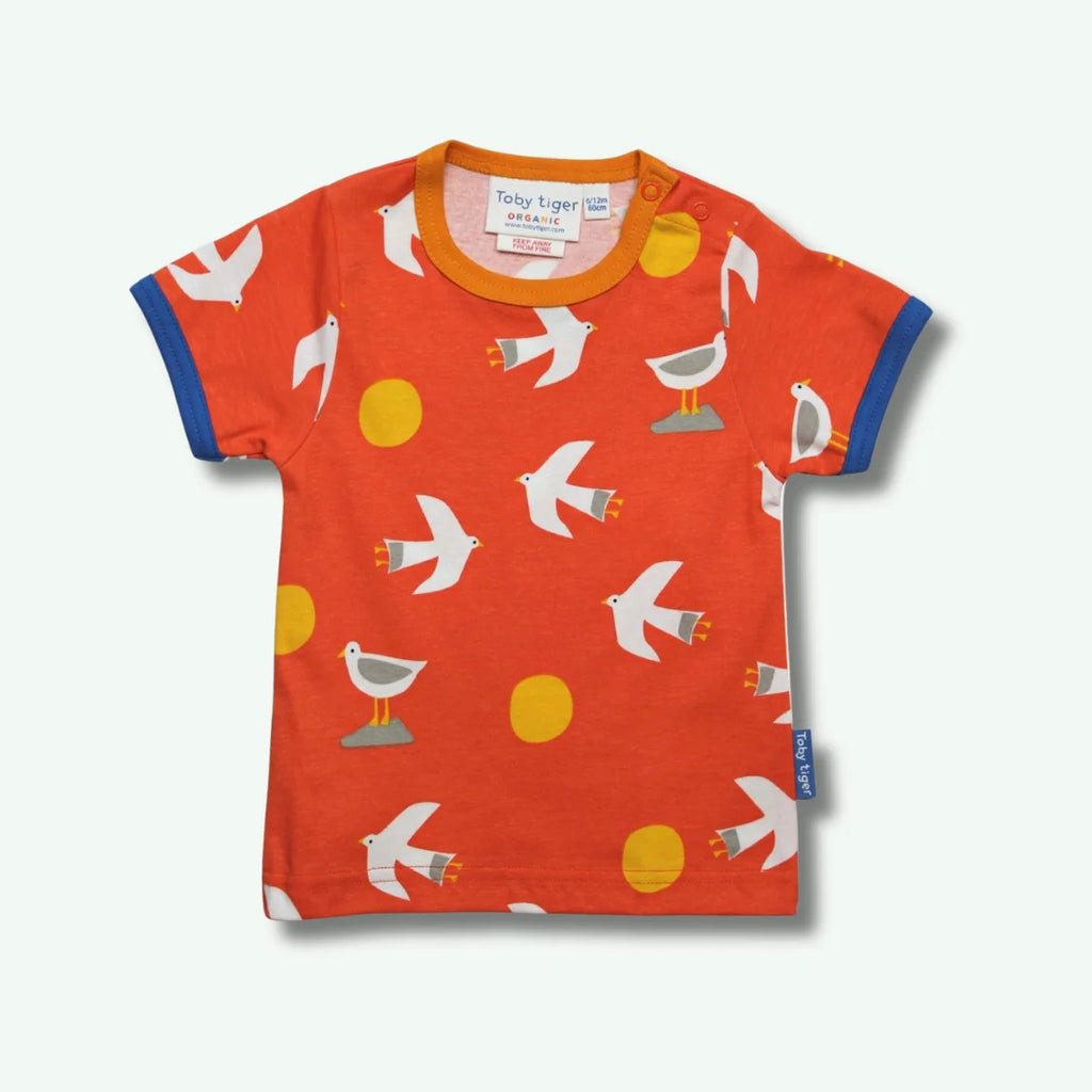 Children's orange t-shirt with bird pattern on a white background