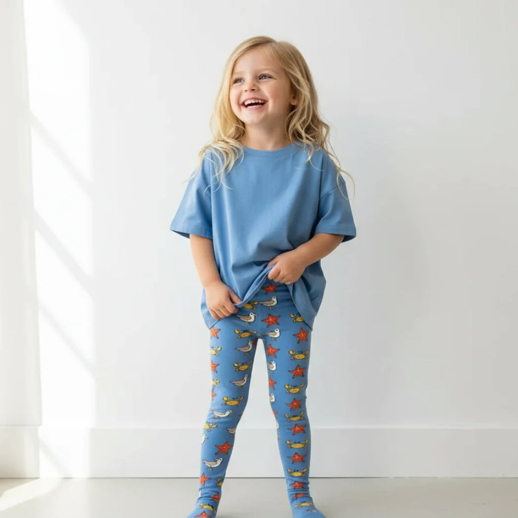 Child wearing a blue outfit with colorful patterns on a white background
