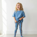 Child wearing a blue outfit with colorful patterns on a white background