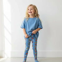 Child wearing a blue outfit with colorful patterns on a white background