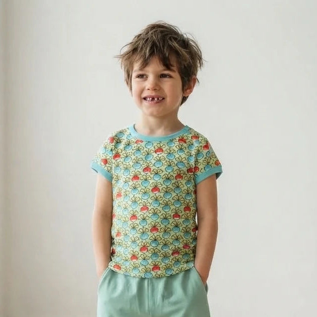 Boy wearing bright organic kids clothes in a well lit room