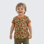 Child wearing a patterned shirt with orange trim on a plain background