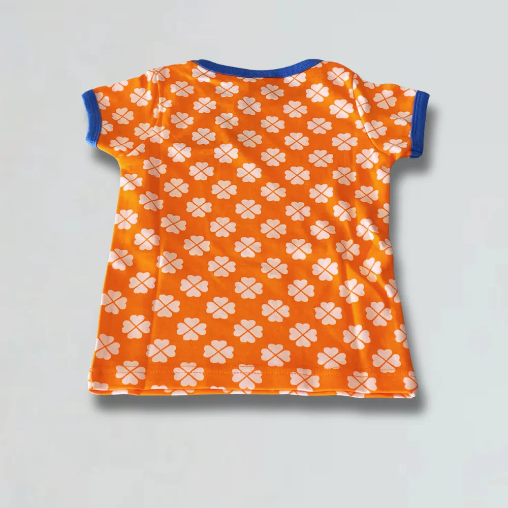 Orange t-shirt with white floral pattern on a light gray background