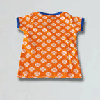 Orange t-shirt with white floral pattern on a light gray background