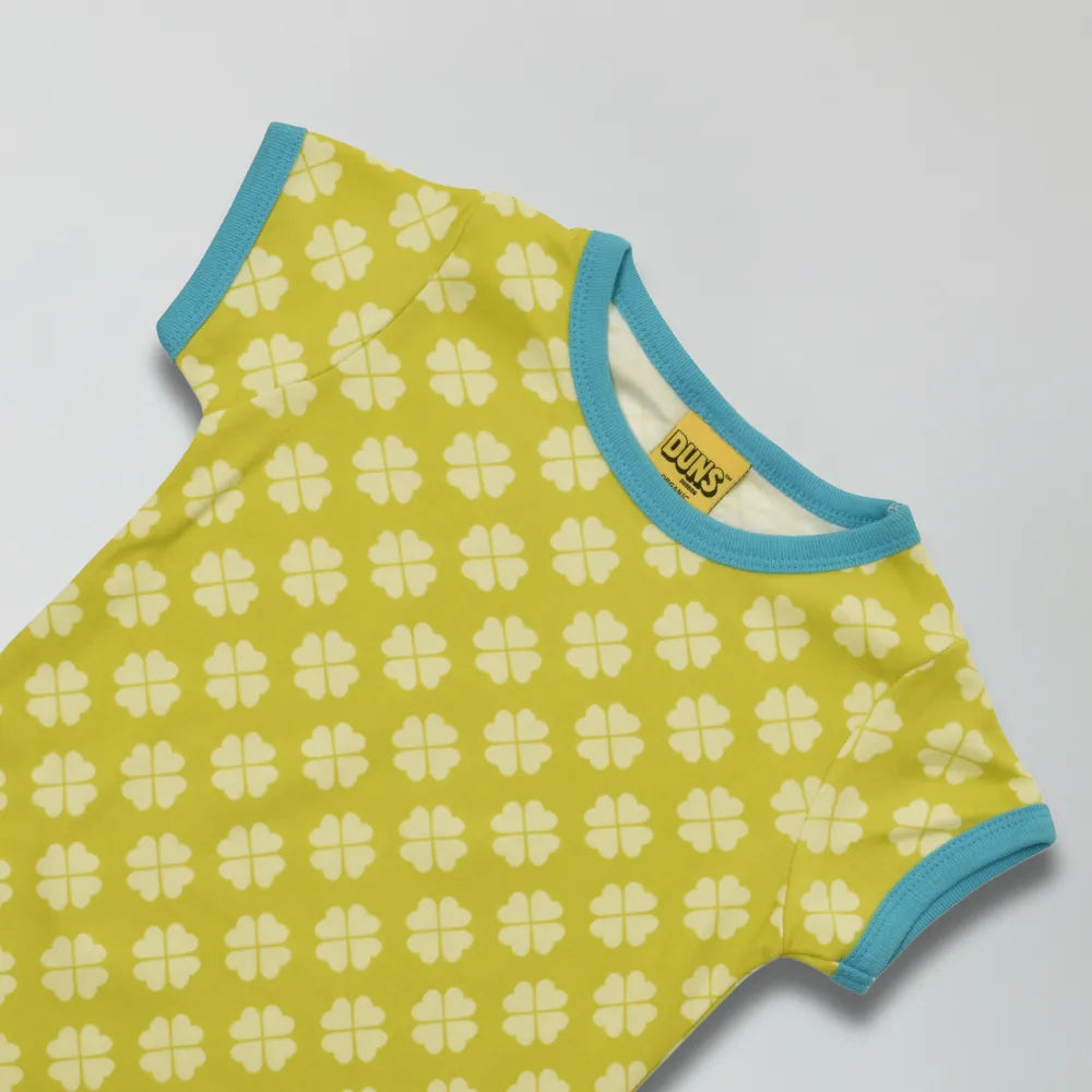 Yellow baby romper with white floral pattern and blue trim on a light gray background