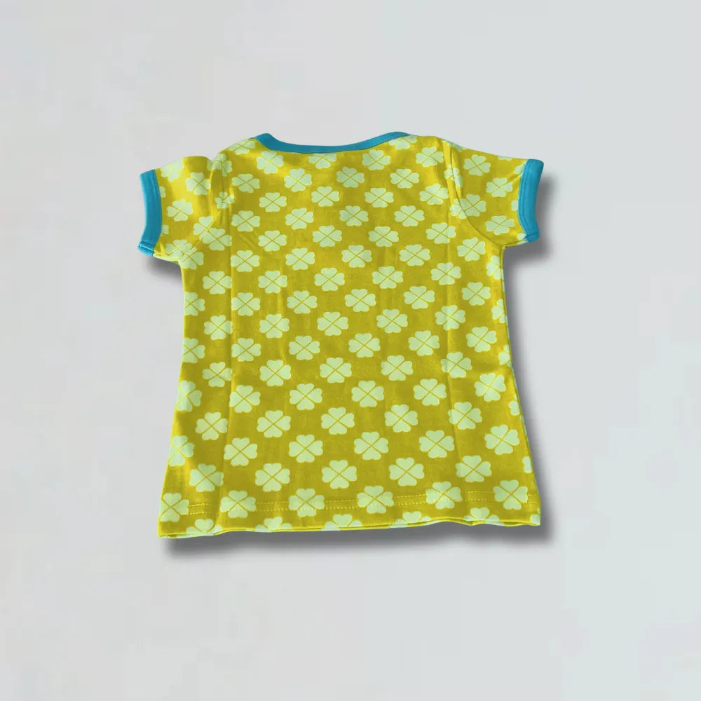 Yellow t-shirt with green paw print pattern on a light gray background