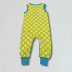 Yellow romper with green floral pattern on a light gray background