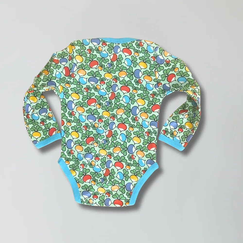 Colorful baby onesie with fruit pattern on a gray background