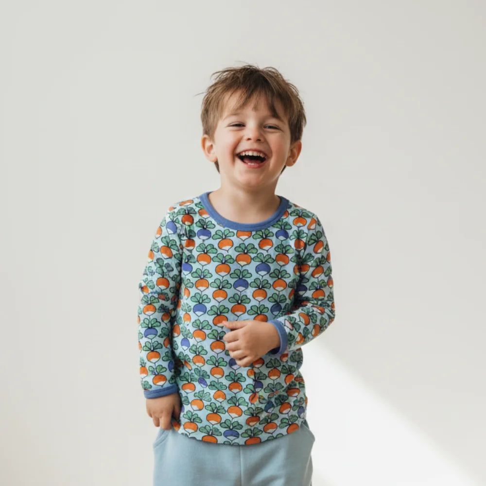 Child wearing a colorful patterned shirt with a plain background