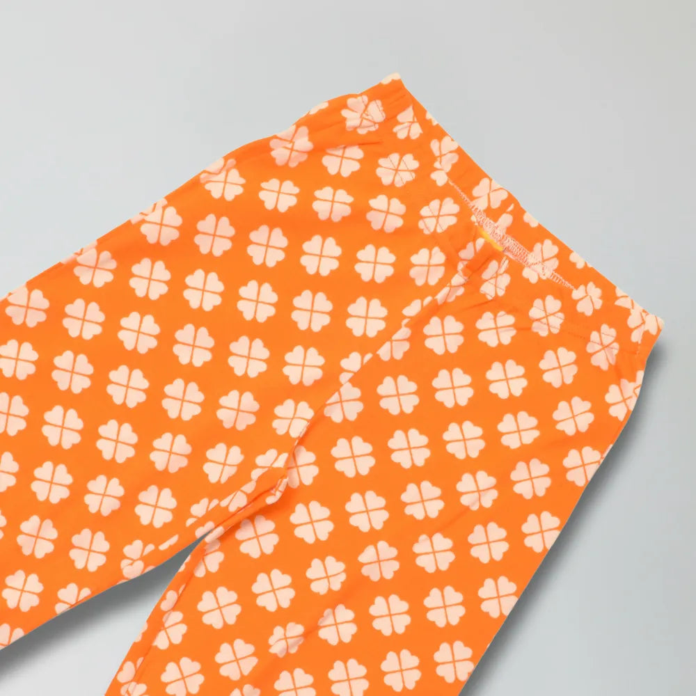 Orange cotton pants with white floral pattern on a gray background