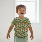 Child wearing a shirt with a carrot pattern in a bright room