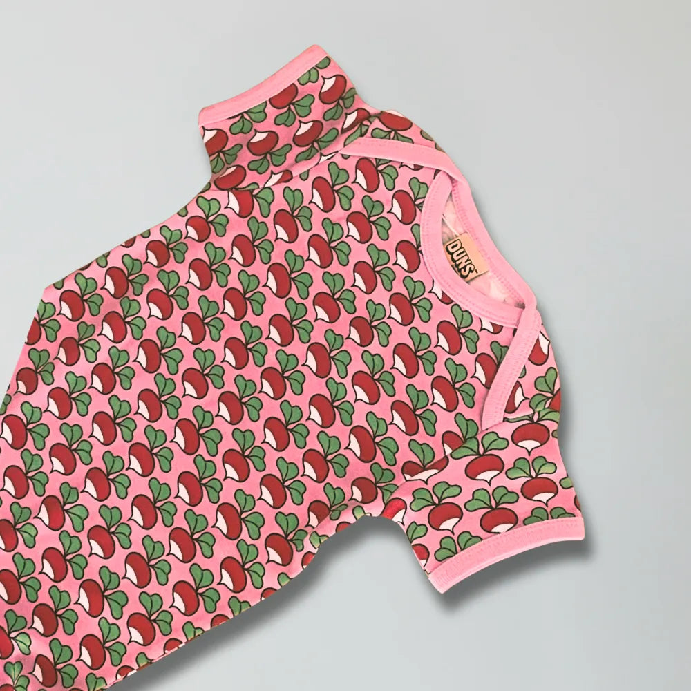 Pink romper with red and green pattern on a gray background