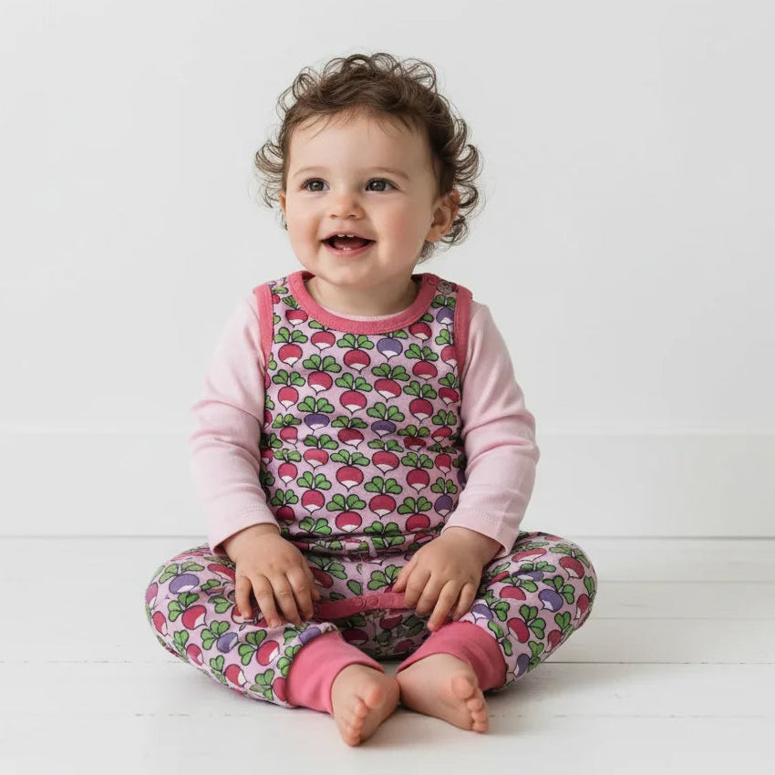 Baby girl clothes of a pink and multicolor outfit with a white background