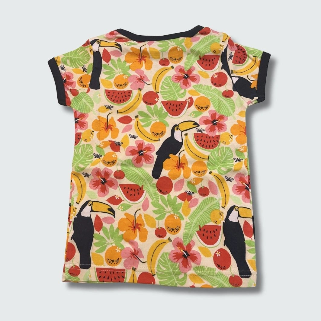 Back view of colorful t-shirt with tropical fruit and bird pattern on a light gray background
