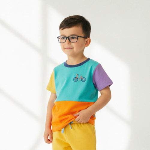 Child wearing a colorful shirt with a bicycle design on a white background