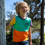Child wearing a colorful shirt with a bicycle design outdoors