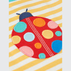 Colorful ladybug patch on a striped fabric background