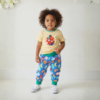 Child wearing a colorful outfit with a ladybug design on a white background
