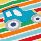 Colorful striped fabric with a blue tractor applique