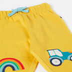 Yellow pants with rainbow and tractor design on a white background
