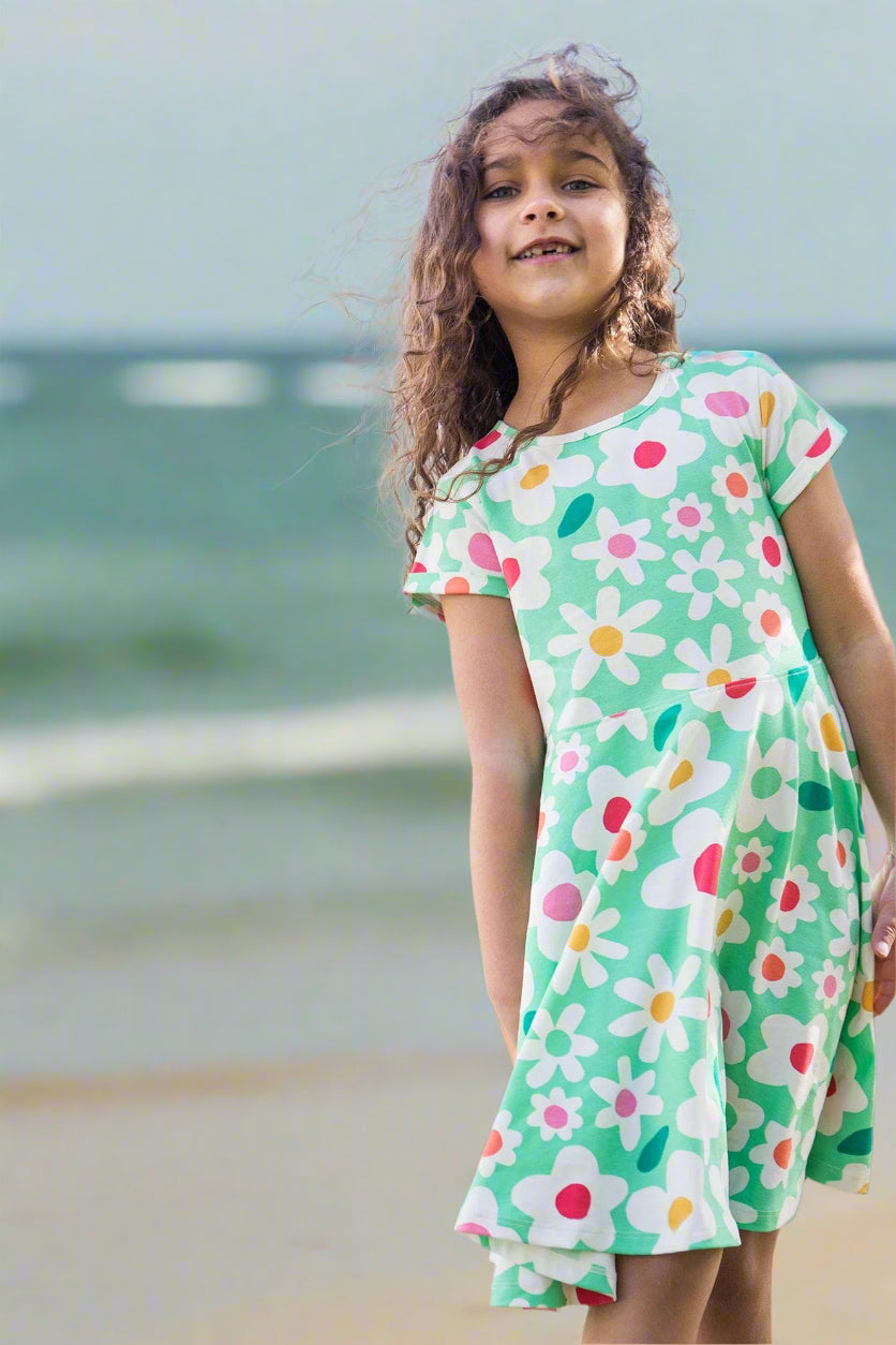Young girl wearing a floral dress in a garden setting