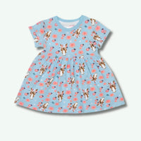 Children's dress with dog and flower pattern on a light blue background