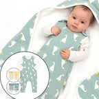 Baby wearing a green baby grow with duck pattern, surrounded by matching items.
