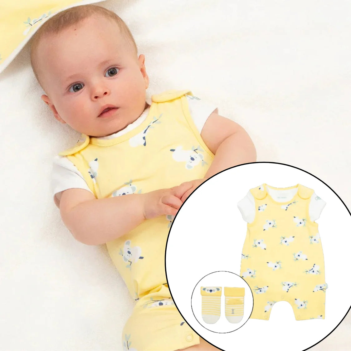 Baby wearing a yellow romper with butterfly pattern on a white background