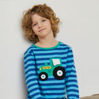 Child wearing a blue striped shirt with a green tractor design on a white background