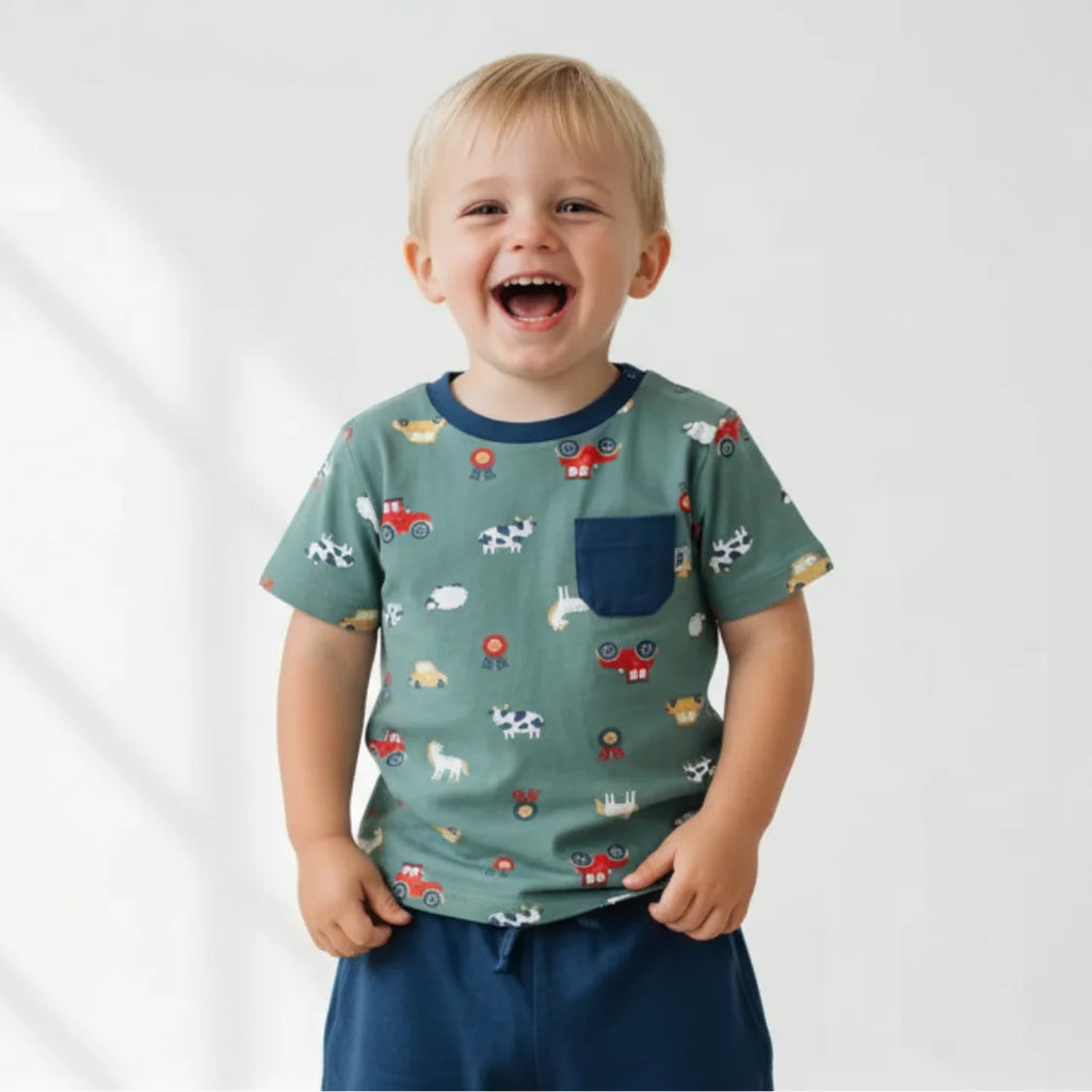 Child wearing a green t-shirt with animal prints on a white background