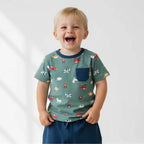 Child wearing a green t-shirt with animal prints on a white background