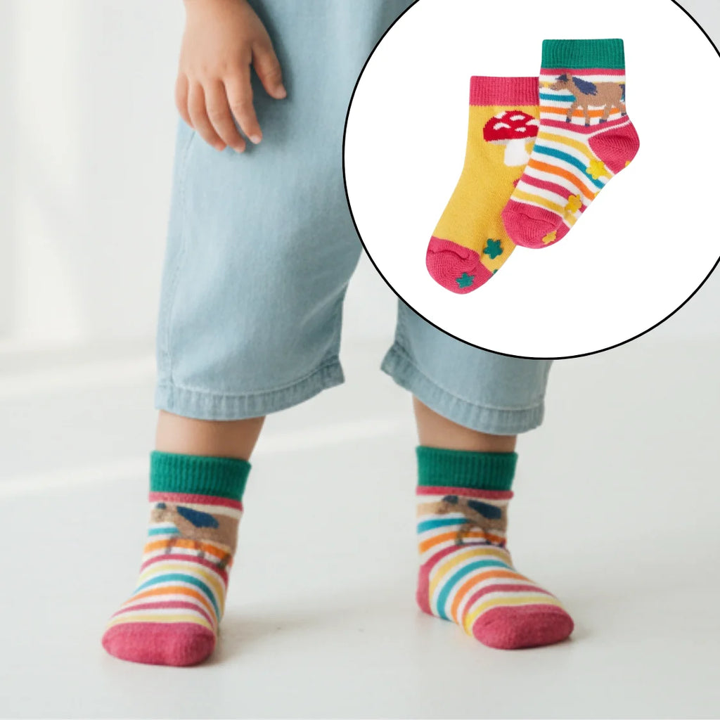 Child wearing colorful striped socks with a close-up inset of the socks.