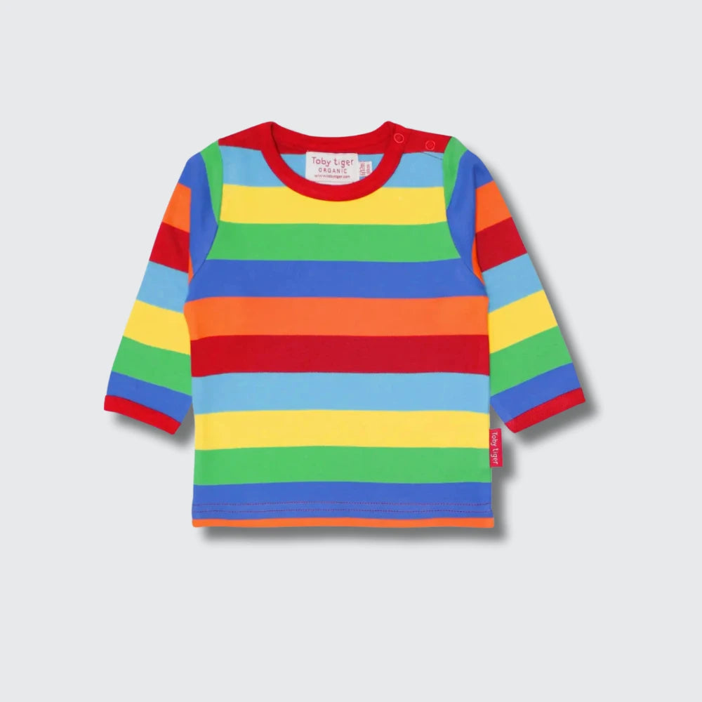 A long-sleeve baby t-shirt with horizontal rainbow stripes in red, orange, yellow, light blue, green, and dark blue, featuring a red crew neck and cuffs, shown on a light gray background.