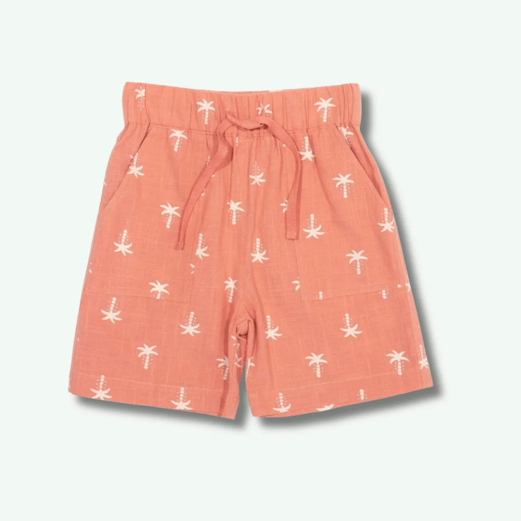 Peach-colored shorts with white palm tree pattern on a light gray background