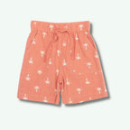 Peach-colored shorts with white palm tree pattern on a light gray background