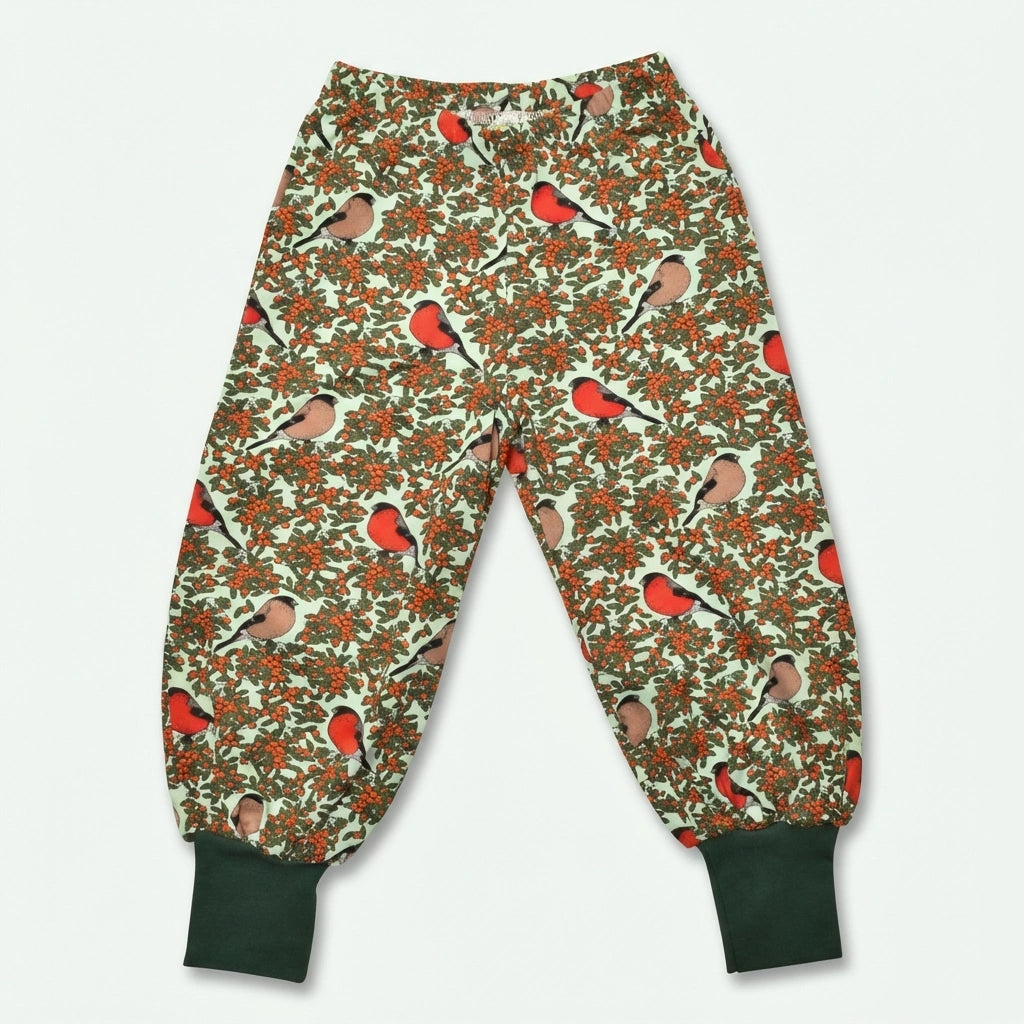 Children's pajama pants with bird and berry pattern on a light background