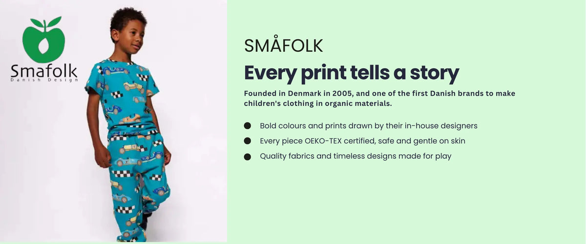 Boy in a Småfolk teal racing car print outfit. Småfolk, every print tells a story. Danish design since 2005. Bold prints drawn by in-house designers, OEKO-TEX certified, made for play.