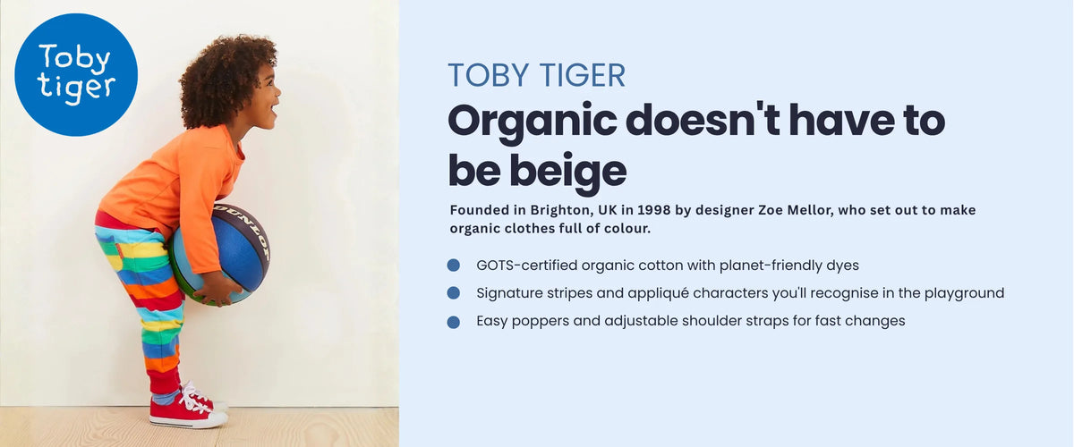 Child in a Toby Tiger orange top and rainbow stripe leggings holding a ball. Toby Tiger, organic doesn't have to be beige. Founded in Brighton, UK in 1998. GOTS-certified organic cotton, signature stripes and appliqué characters, easy poppers and adjustable straps.