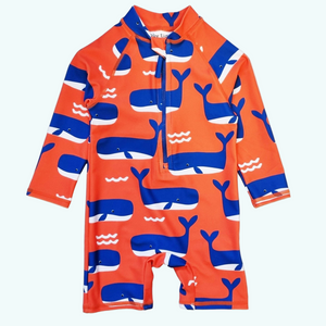 Orange children's swimsuit with blue whale patterns on a white background